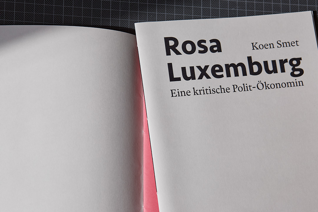 A close up photography of a brochure on Rosa Luxemburg by Koen Smet. It shows a black side sewn binding.