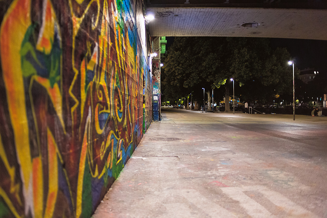 Streetphotography of a graffiti wall and the Donaukanal in Vienna.