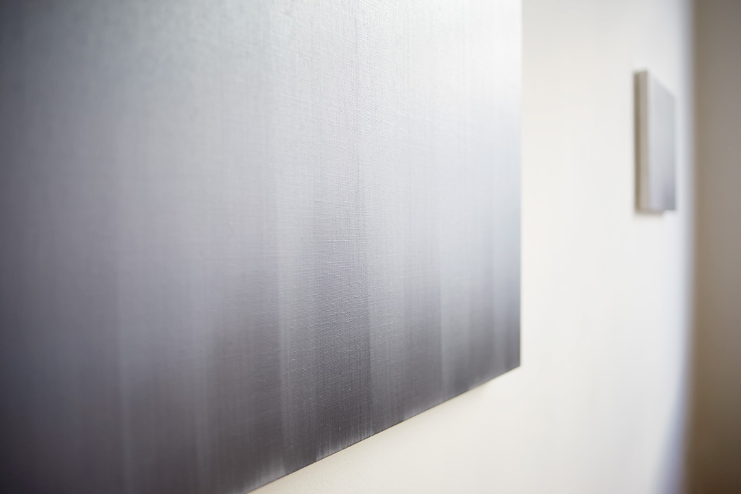 A dynamic, close up photography of Brume III, a painting by Tom Van Puyvelde, in the Common Sense Art Gallery in Vienna. The close up shows the vertical brush strokes of the painting. In the background the painting Brume IV is visible.